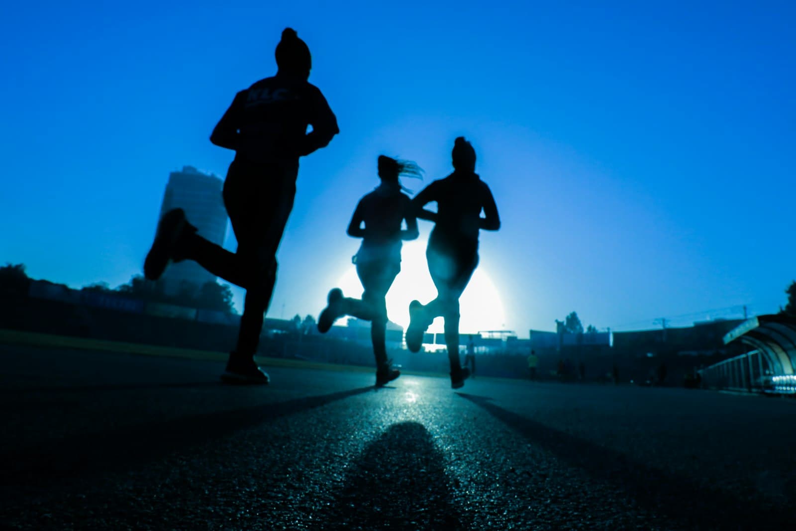 Three runners training together at sunrise